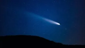 Cielo nocturno con el Cometa Lemmon visible sobre un paisaje montañoso de Morelos.