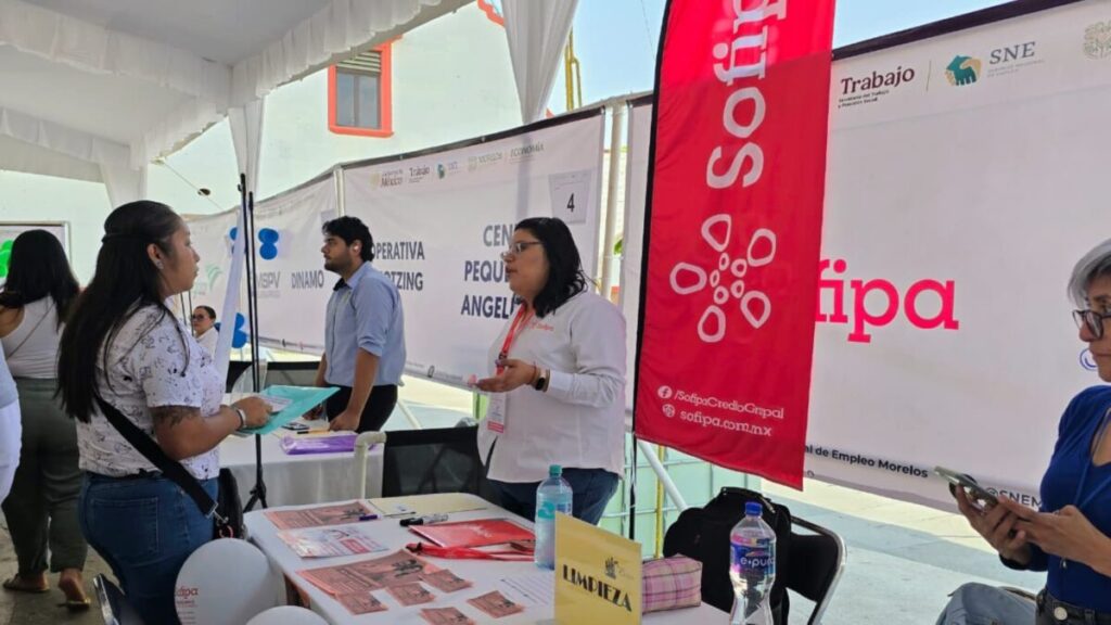 Personas en feria de empleo en Cuernavaca con stands de empresas y ambiente de inclusión laboral.