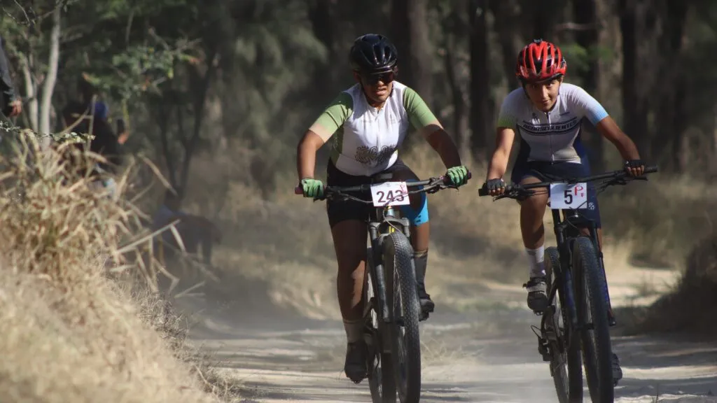 Ciclista juvenil compite en un circuito de ciclismo de montaña durante una carrera clasificatoria rumbo a la Olimpiada Nacional.