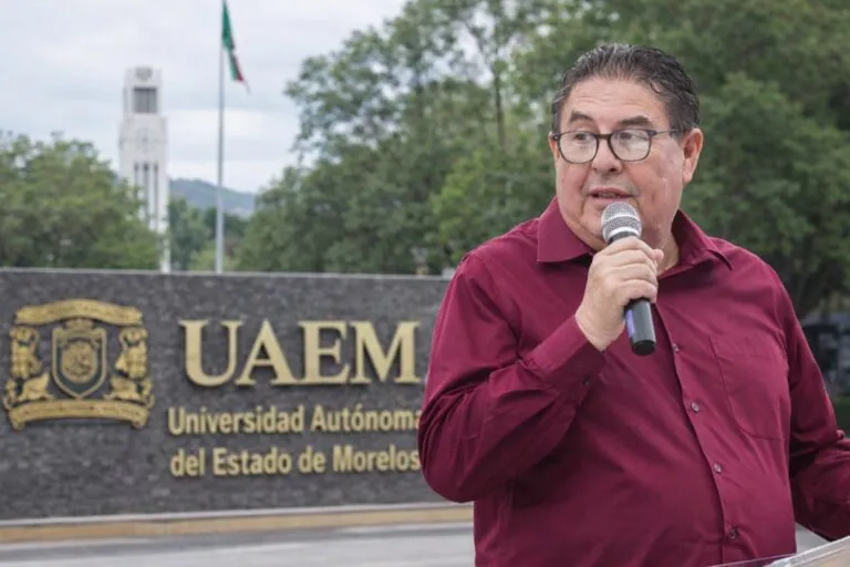 Víctor Aureliano Mercado Salgado durante acto público con la Universidad Autónoma del Estado de Morelos de fondo, en contexto de cuestionamientos por contratos de seguridad otorgados a la empresa Hebron.