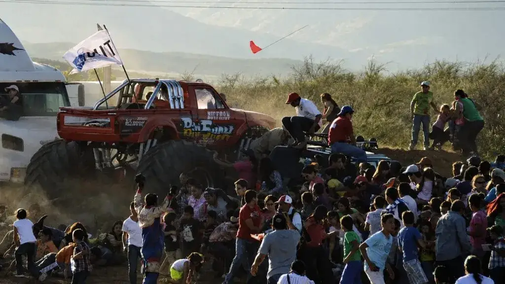 Escenario para un evento masivo con asistentes y estructuras metálicas que representan el debate sobre la seguridad tras el Aeroshow.