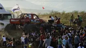 Escenario para un evento masivo con asistentes y estructuras metálicas que representan el debate sobre la seguridad tras el Aeroshow.