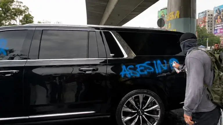 Cuauhtémoc Blanco junto a una camioneta rodeada por activistas que le gritan consignas durante una protesta antes del partido México vs Inglaterra.